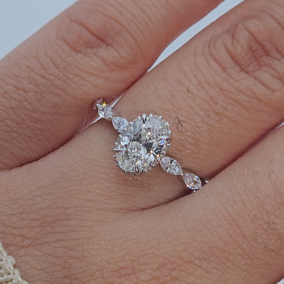 360 view of oval diamond ring with marquise side stones.
