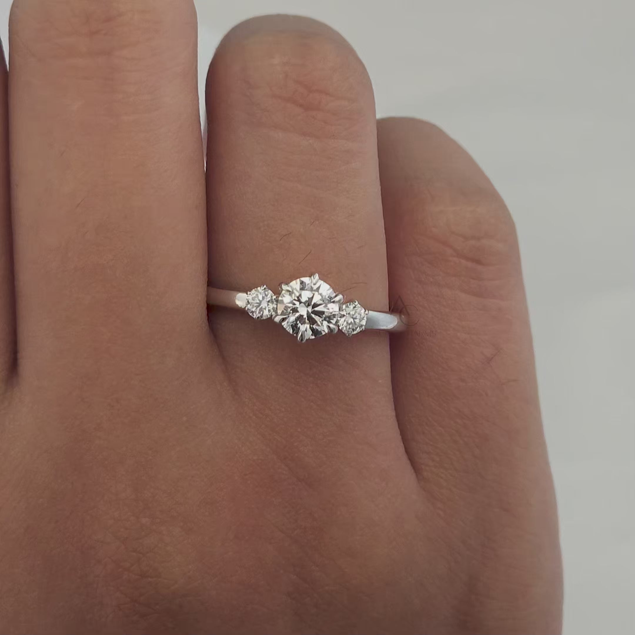 360° view of a three-stone round diamond engagement ring showcasing its brilliance.