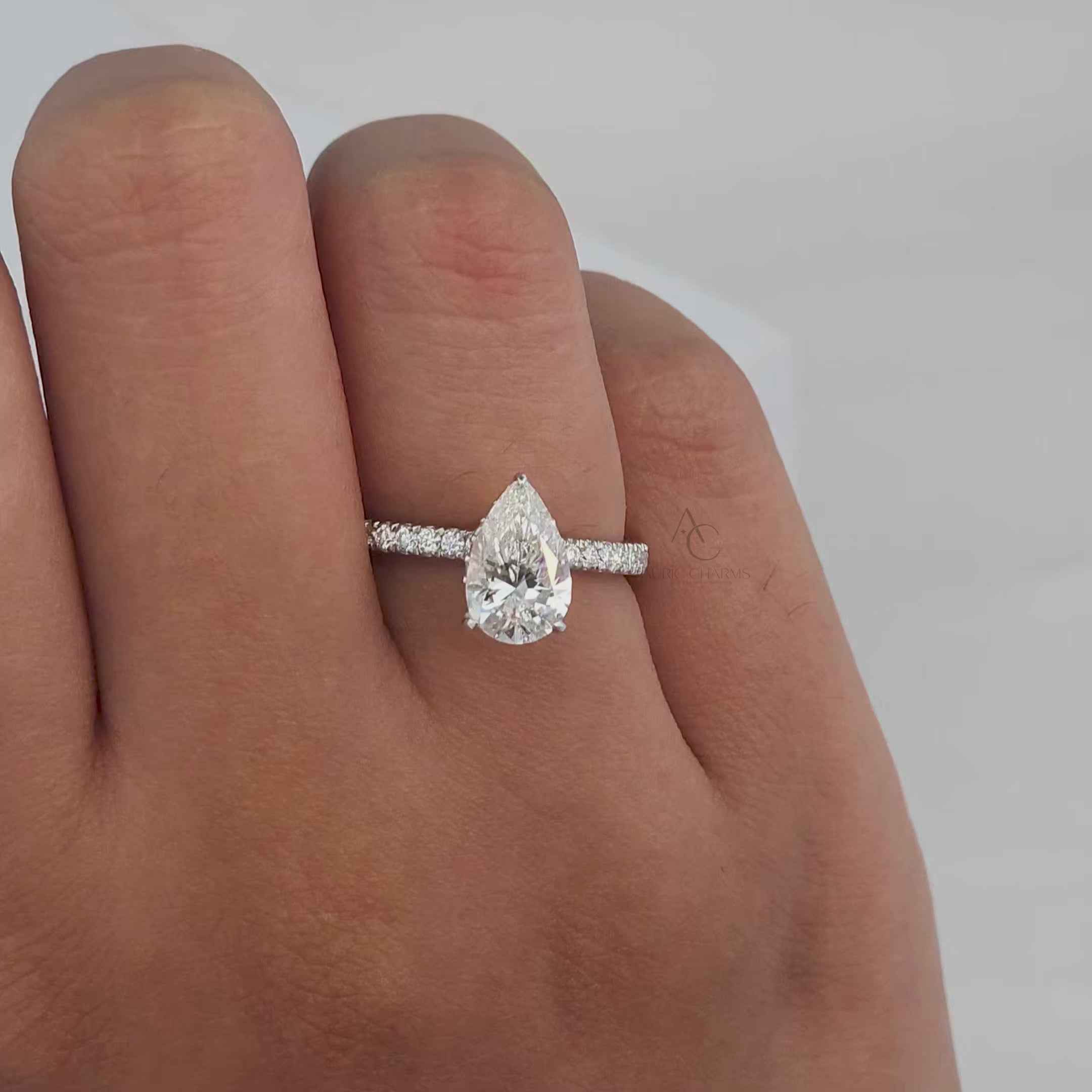 360-degree rotating view of a pear-cut diamond ring with a halo and diamond band.