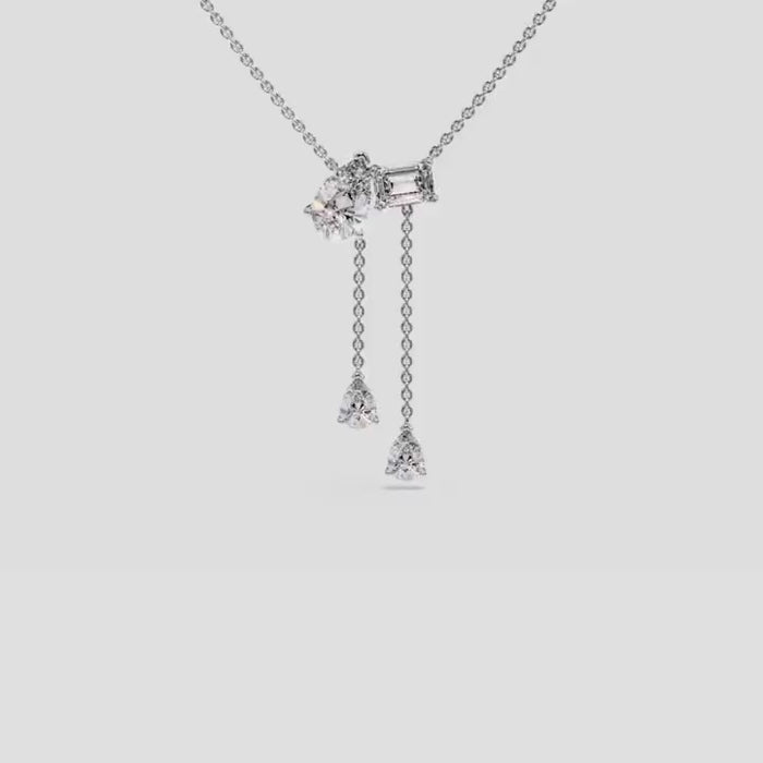 Elegant Toi et Moi pendant necklace with lab-grown diamonds, featuring emerald and pear cuts, worn on neck for a luxurious appeal.