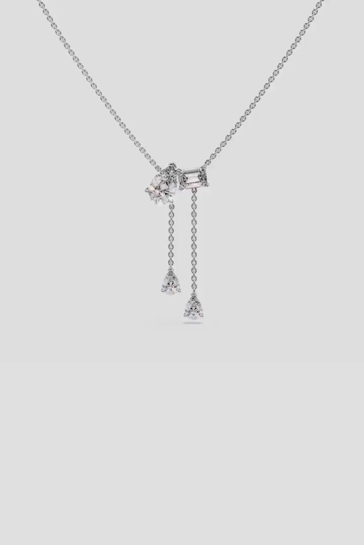 Elegant Toi et Moi pendant necklace with lab-grown diamonds, featuring emerald and pear cuts, worn on neck for a luxurious appeal.