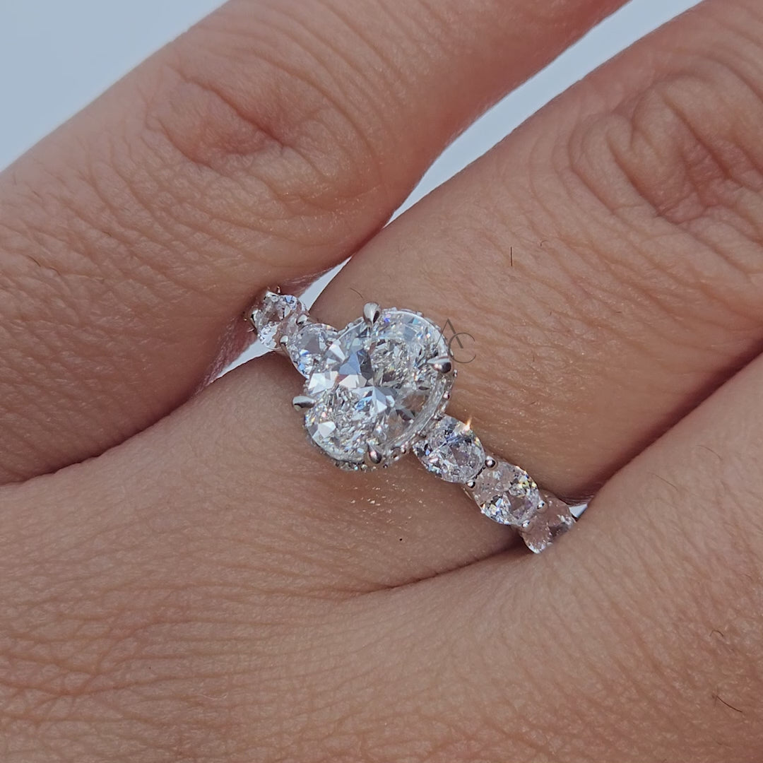 Oval cut diamond ring with side stones shown from all angles, capturing sparkle and design.