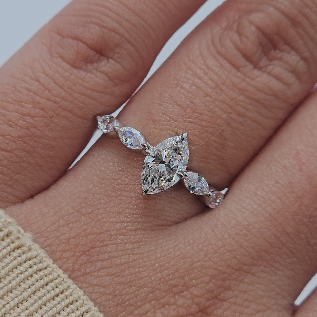 Marquise-cut diamond ring with side stones displayed from multiple angles, showing brilliance.
