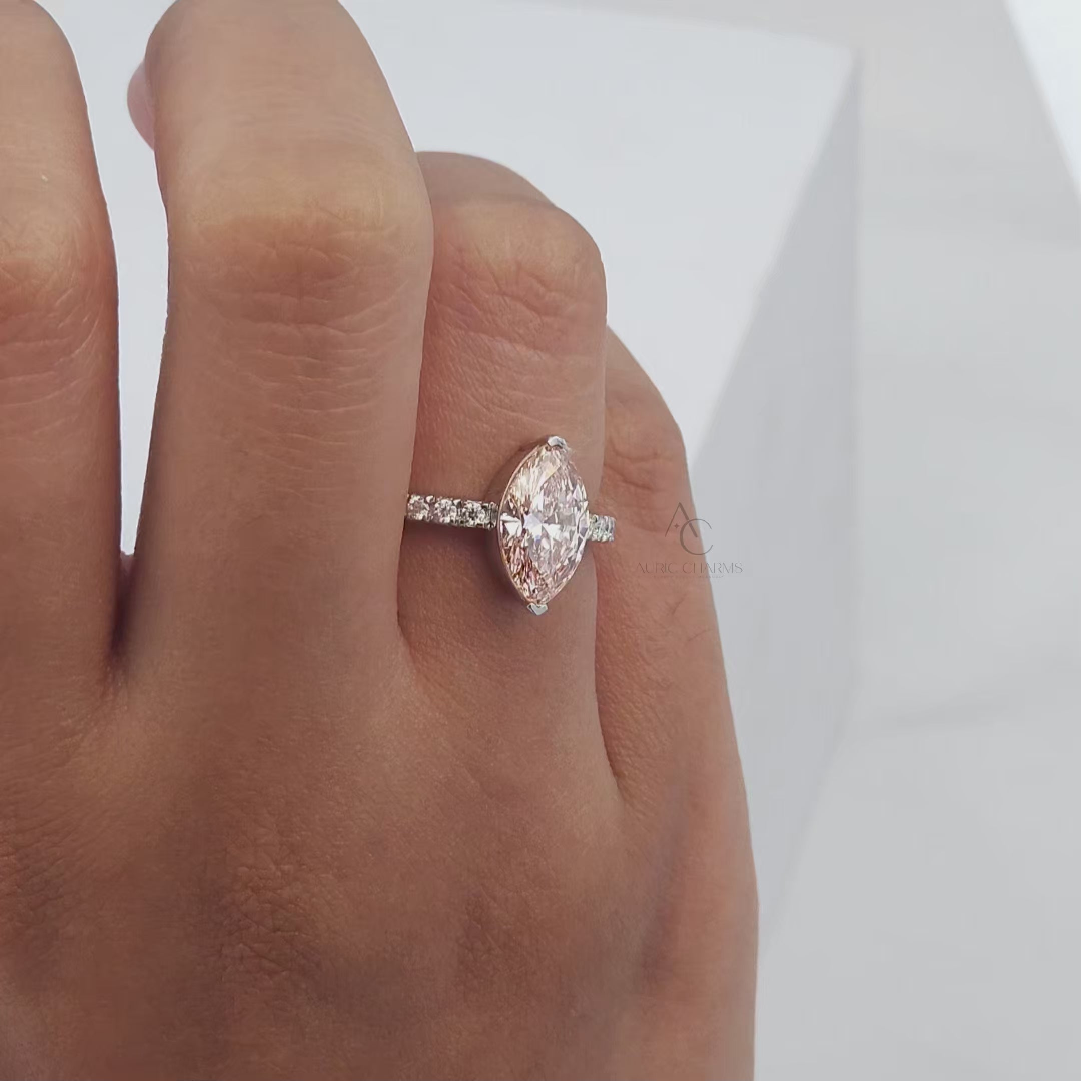 Rotating close-up video of a marquise-cut pink gemstone ring with a diamond-studded silver band, perfect for elegant occasions.