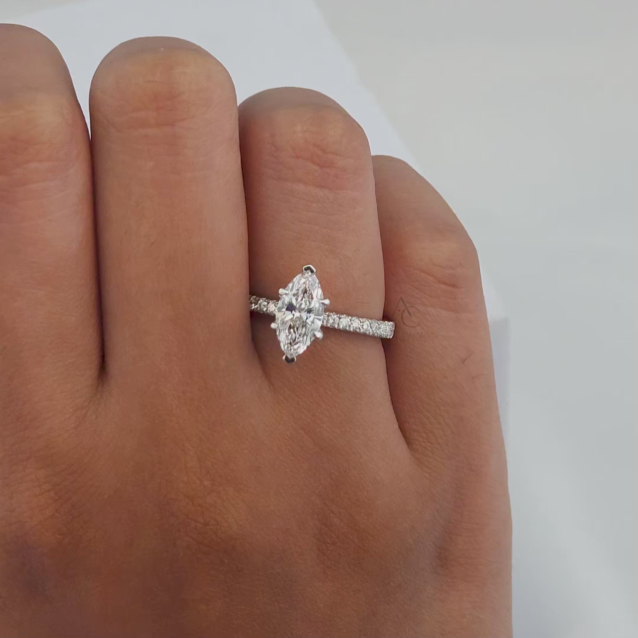 A high-definition video showcasing a marquise-cut diamond engagement ring with a pavé platinum band, rotating to highlight its sparkle, detailing, and craftsmanship from various angles.