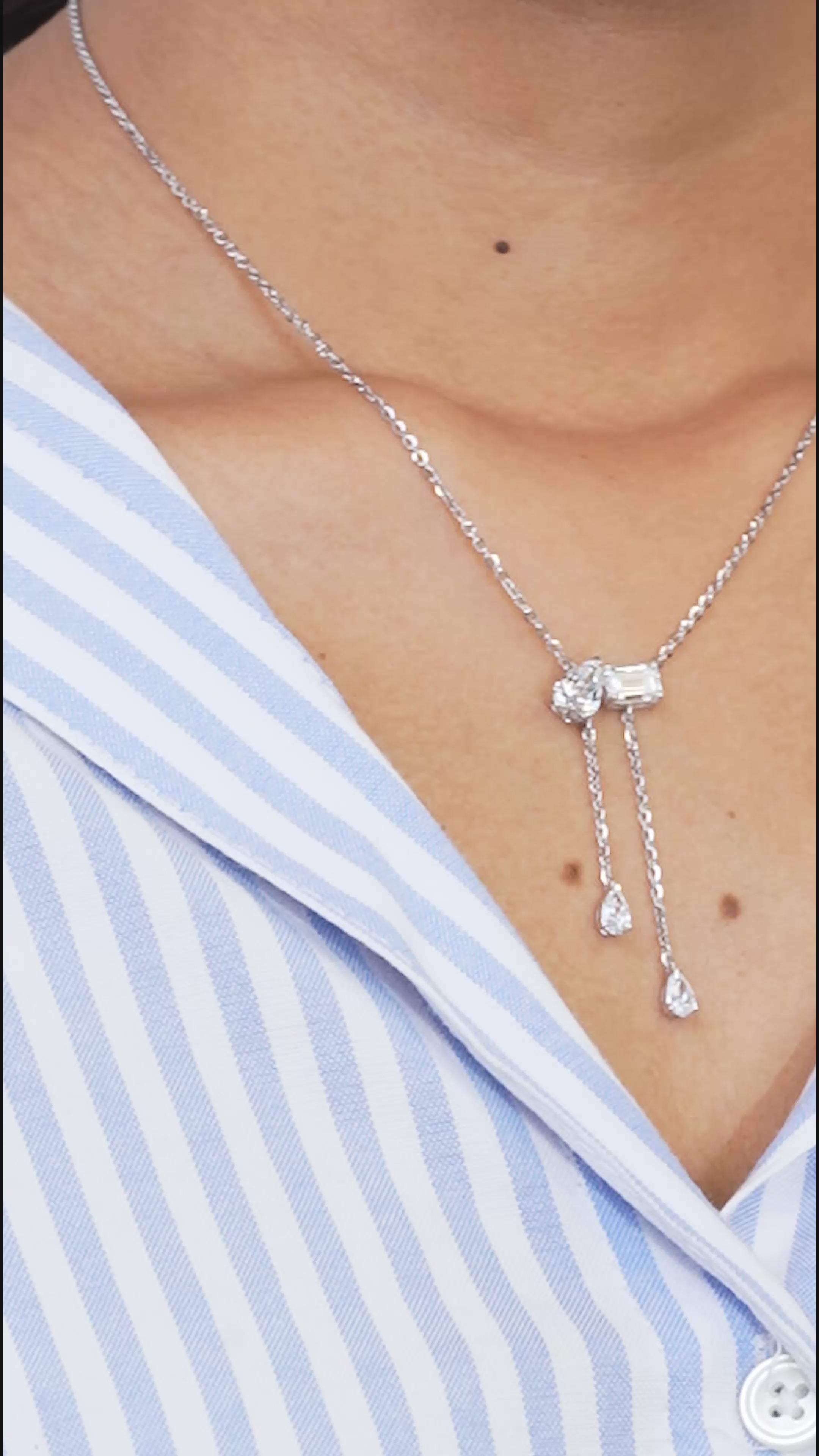 Elegant Toi et Moi pendant necklace with lab-grown diamonds, featuring emerald and pear cut, worn on neck, embodying luxury.