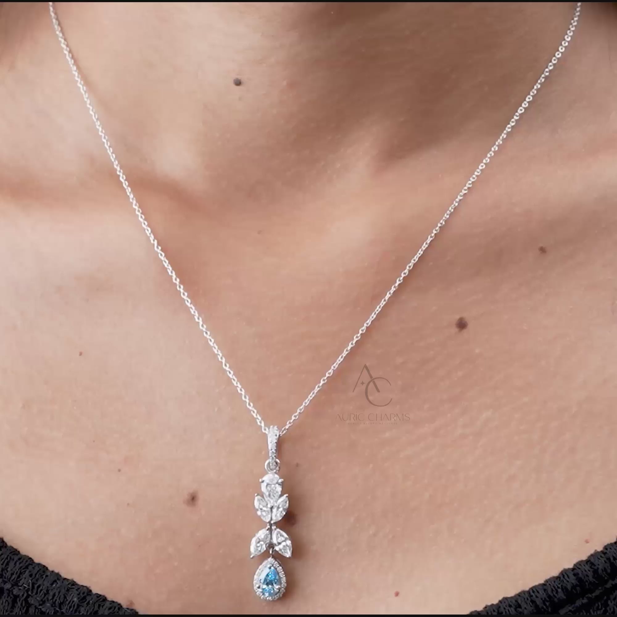 360-degree view of white gold pendant with lab-grown diamonds and blue sapphire drop.