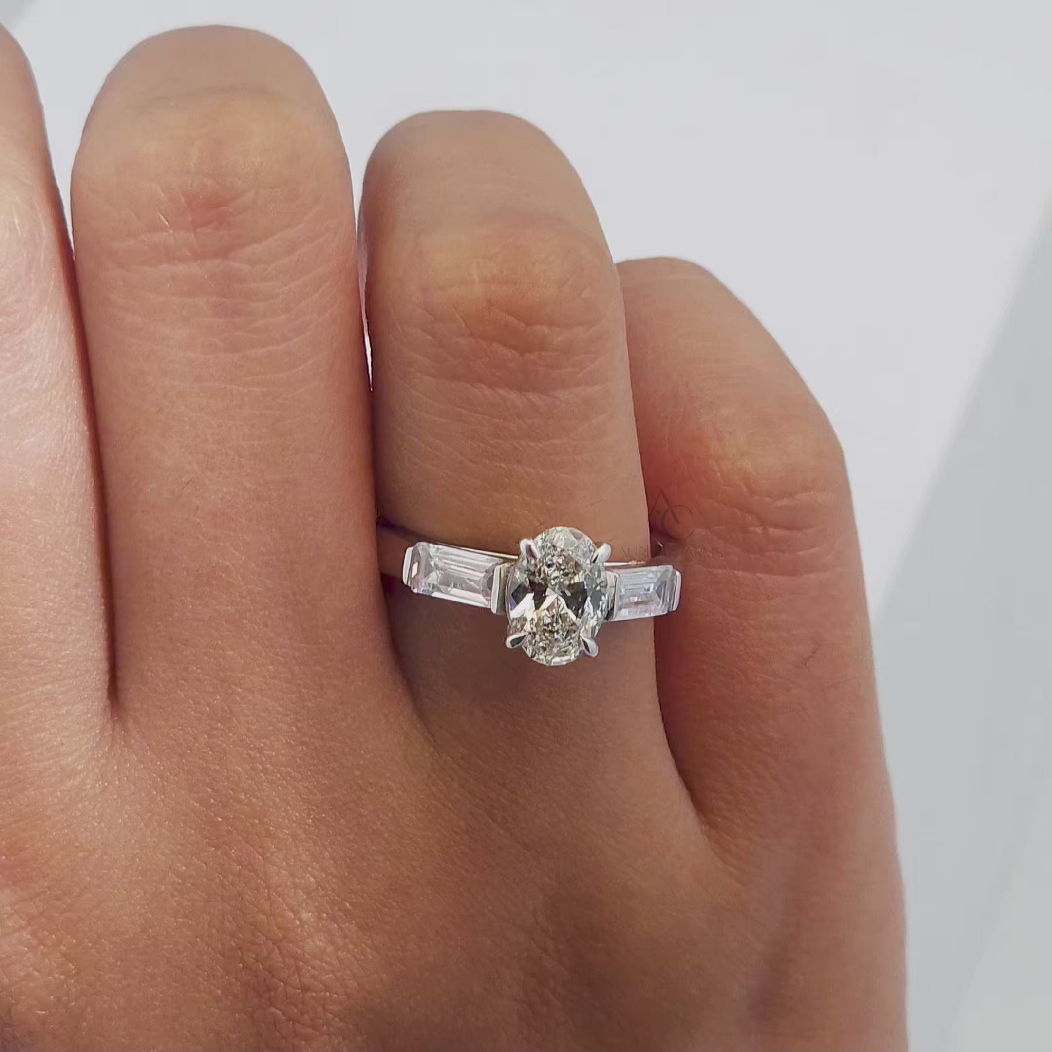 Close-up video of a sparkling oval diamond ring with tapered baguettes, capturing brilliance and elegance.