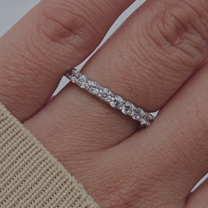 Close-up rotation of a diamond eternity band, highlighting round diamonds and white gold.