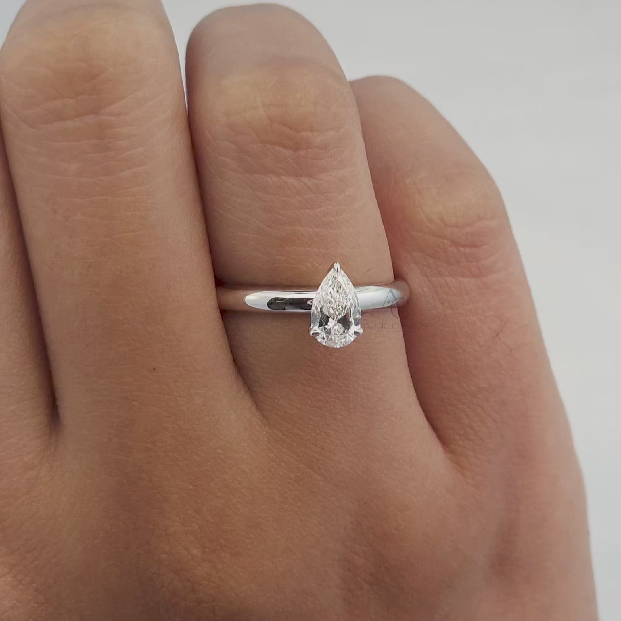 A stunning showcase of a pear-cut lab-grown diamond solitaire ring. The video highlights the brilliance and fire of the diamond from different angles, emphasizing the ethical and sustainable aspects of the lab-grown diamond set on a platinum band.