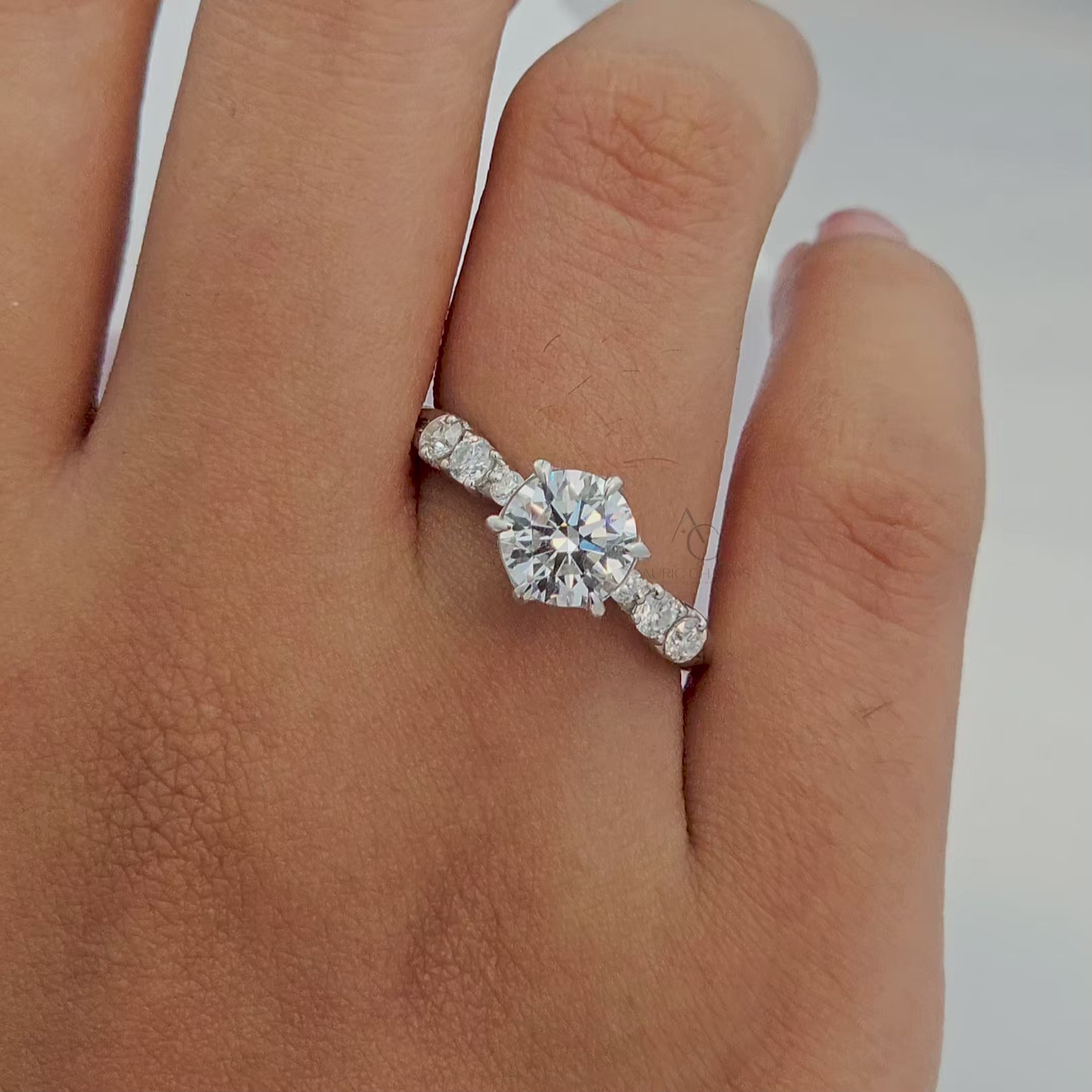360-degree view of a round lab-grown diamond engagement ring with intricate pave detailing on the band.