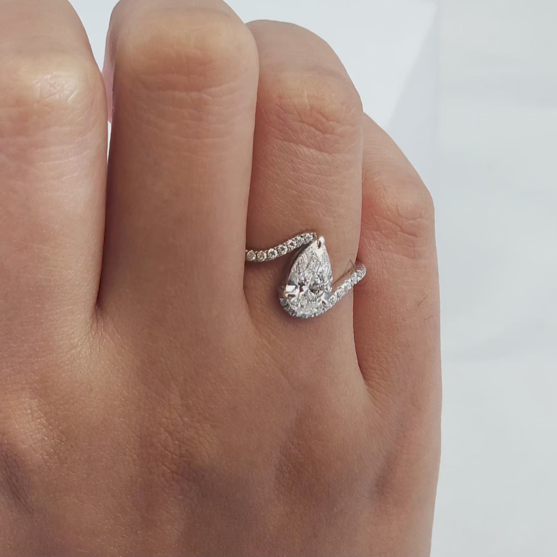 360-degree view of a pear-shaped diamond ring with a swirl pavé diamond band.
