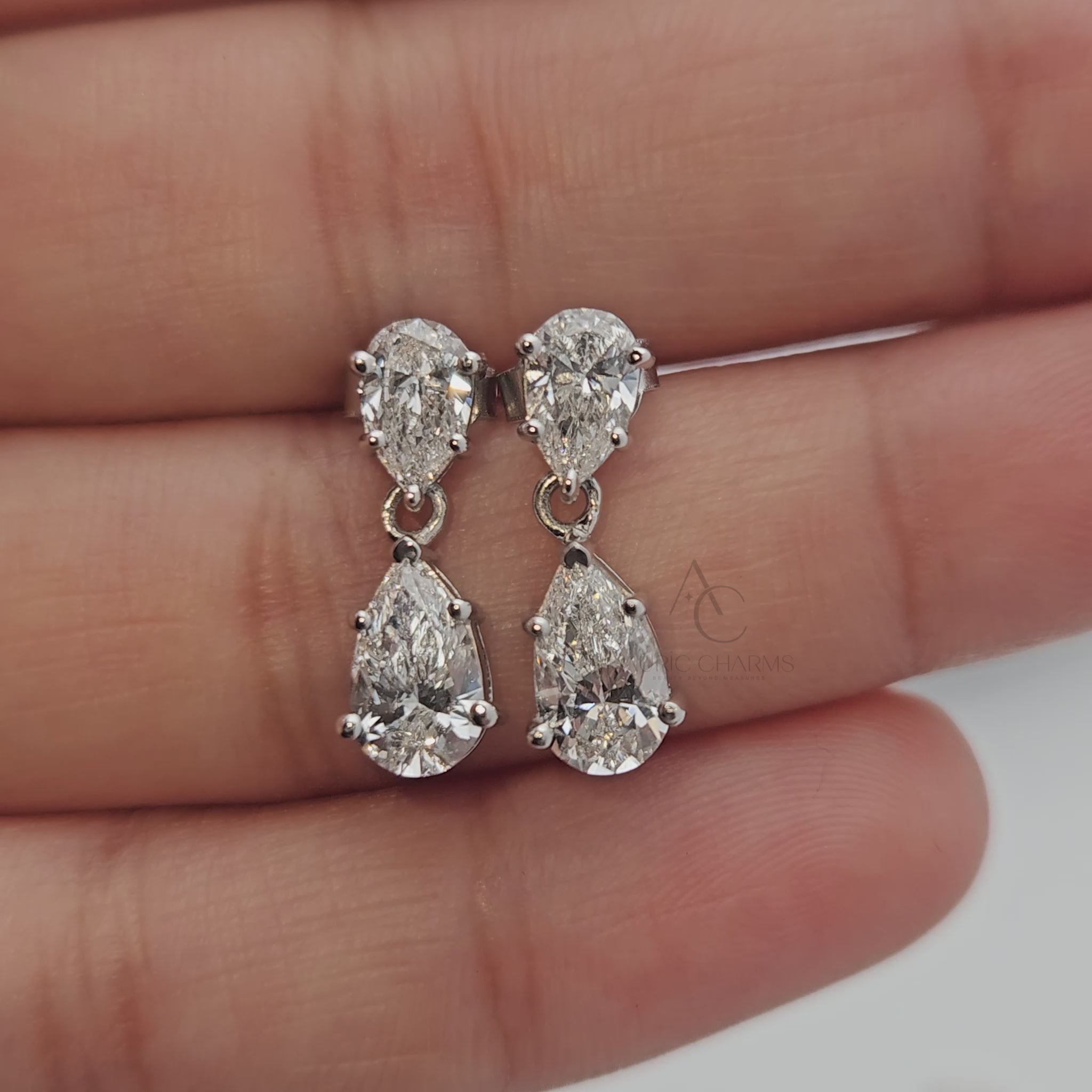 Video of pear-cut diamond drop earrings, rotating to show sparkle and design details.
