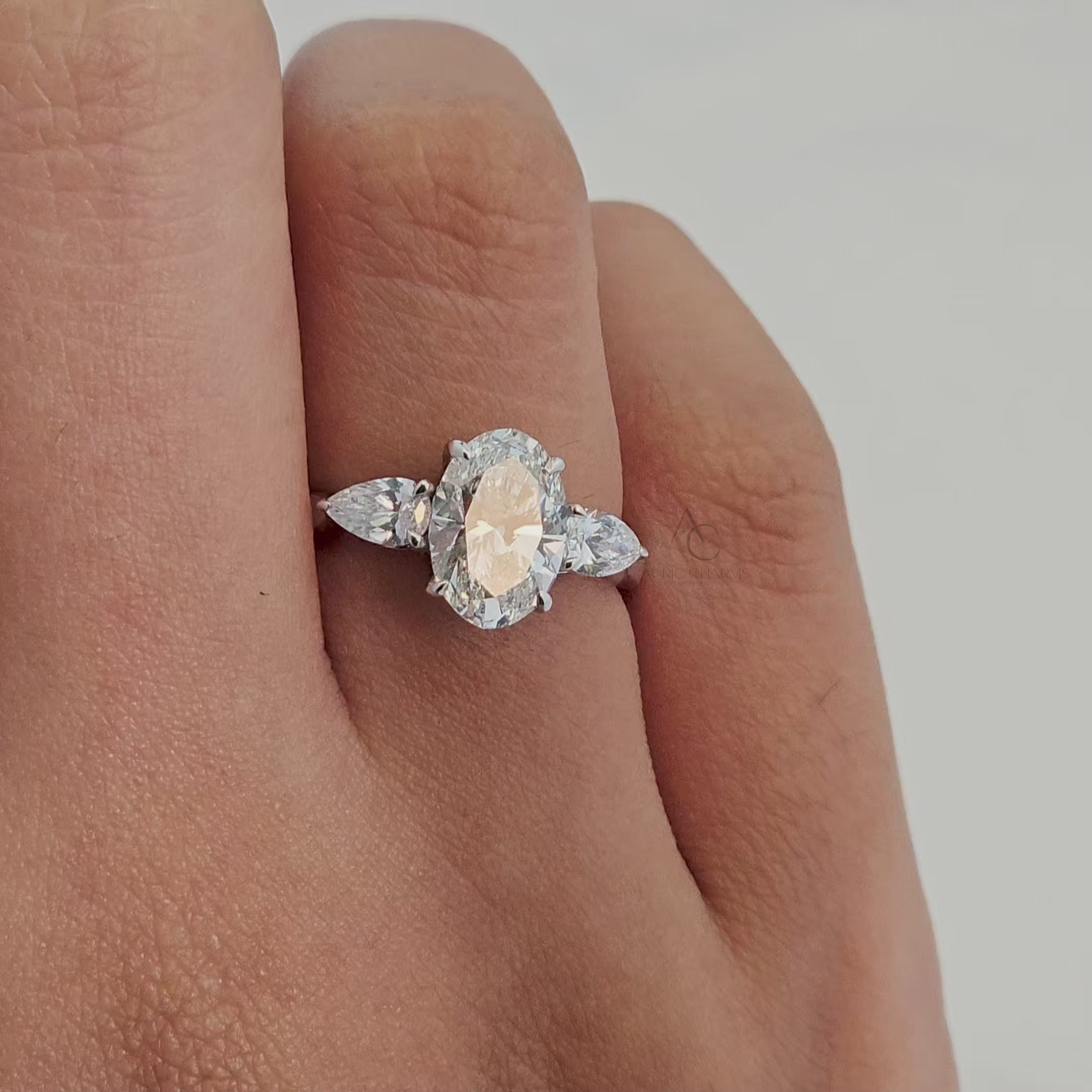 360° video showcasing an oval diamond ring with pear-shaped accents on white gold band.