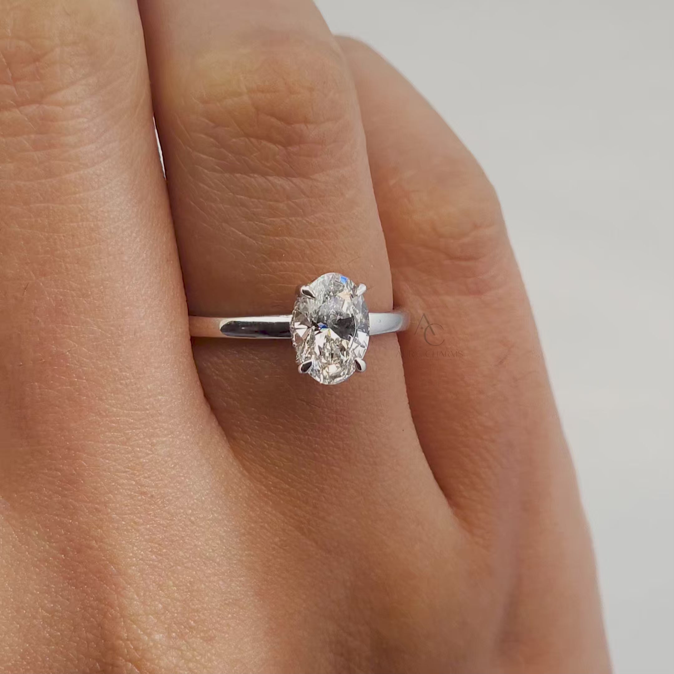 360-degree rotating video of an oval-cut solitaire diamond ring with a polished metal band.